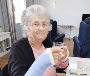 An Ash Lodge Care Home resident enjoying lunch with a glass of white wine