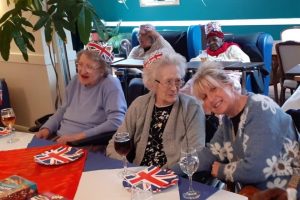 Residents enjoying an activity as Ash Lodge, with a visiting relative